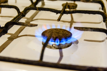 Gas burner on the white kitchen stove