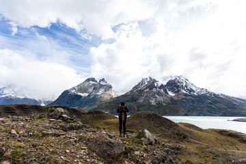 woman standing with arms wide open with Torres del Paine mountain range in the background