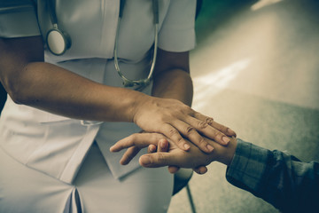Nurse holding the hand of a patient man, showing sympathy and kindness, vintage style