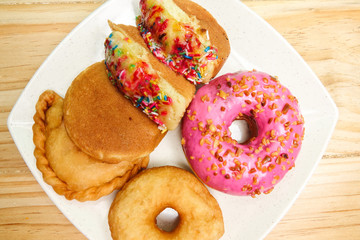 Colorful and tasty donuts on a wooden background