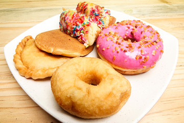 Colorful and tasty donuts on a wooden background