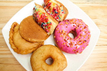 Colorful and tasty donuts on a wooden background
