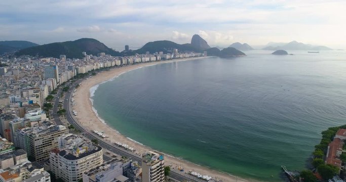 Flying low backwards above Copacabana Beach in Rio de Janeiro, Brazil. Aerial view