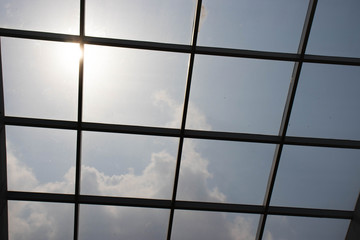 Square structures in front of the shiny and bright sun for background.
