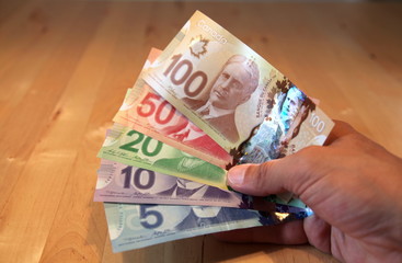 Canada's new polymer bank notes, holding in hand, yellow light