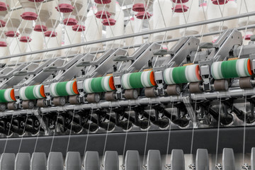 Machinery and equipment in the workshop for the production of thread, close-up. interior of industrial textile factory