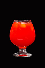 Single-color opaque cocktail, orange, red refreshing in a low plump glass with ice cubes with a taste of tomato, grapeprut, strawberry. Side view. Isolated black background