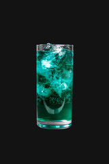 Single-colored transparent cocktail, blue, blue refreshing carbonated in a high glass with ice cubes. Side view. Isolated black background. Drink for the menu restaurant, bar, cafe