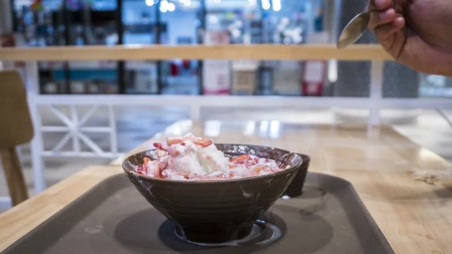 Time lapse of Bingsu, The shaved ice with slightly milk cream topped with cream cheese and fresh strawberry. Woman hand strawberry stack. 