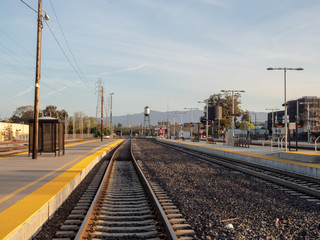 Fototapeta premium A railroad stretches into the horizon going from a train station