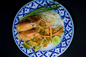 Padthai food from Thailandม  stir-fried rice noodles with Tiger prawn, isolated on black background