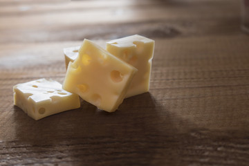 a few small pieces of hard cheese on a board