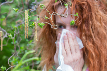 a woman is outdoors and has hay fever
 - obrazy, fototapety, plakaty