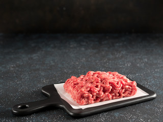 raw minced beef on light gray cement background
