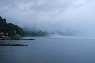 Settlement at lake coast in the fog