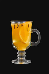 One-color opaque cocktail, yellow mulled wine in a high glass with a handle with spices and a slice of lemon, orange. Side view. Isolated black background. Drink for the menu restaurant, bar, cafe