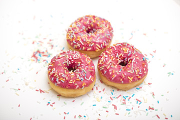 pink donuts with sprinkles on white 