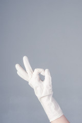 Fototapeta na wymiar Male hand in latex glove. OK sign. on dark background