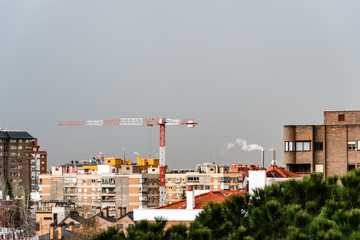 Cityscape with construction crane against gray sky