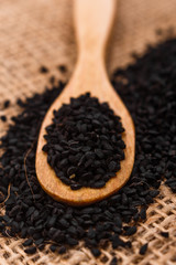 grains of black cumin and oil on the rustic background