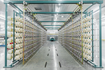 textile yarn on the warping machine. machinery and equipment in a textile factory