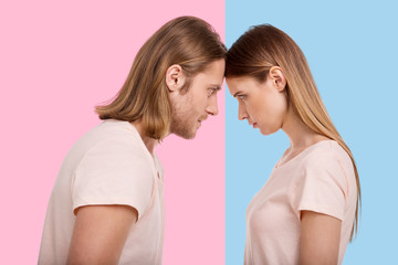 Competition of stubborn. Pretty young woman and her boyfriend pressing their foreheads against one...