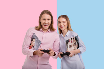 Game lovers. Upbeat young man and his girlfriend playing a video game with controllers while...