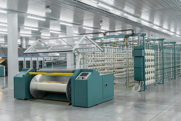 textile yarn on the wrapping machine is screwed on the big shaft. machinery and equipment in a...