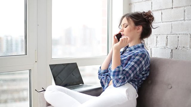 young usinesswoman working at her laptop, is given upsetting news over the phone