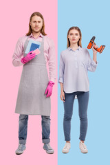 Different responsibilities. Pretty young woman posing with a screw gun while her boyfriend wearing an apron, rubber gloves and holding sponges for cleaning