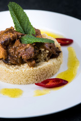 Delicious cooked couscous with meat on a white plate