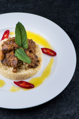 Delicious cooked couscous with meat on a white plate