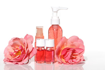 Rose extract. Cosmetics set with rose extract.Serum in  ampoules, tonic and gel for face skin, flowers of roses on white background.