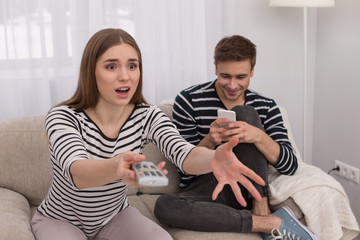 Wonderful film. Emotional excited woman watching a film and her boyfriend typing on his phone