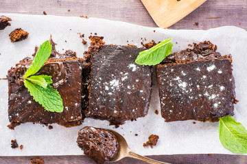 Pieces of homemade chocolate brownies with leaves of mint. Top view