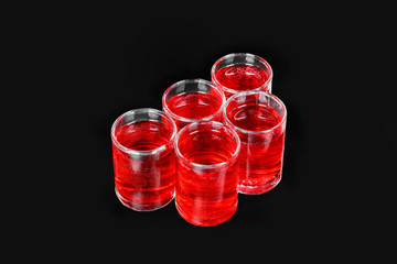 Monochrome transparent cocktails, a set of shots a handful, five servings, with a taste of berries, cherries, strawberries, greiprut, carbonated. Side view from above Isolated black background.