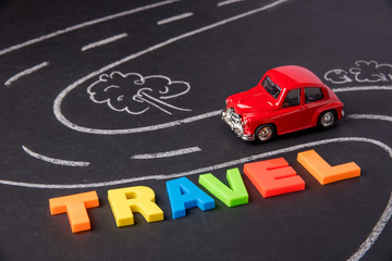 Toy car on the road and inscription plastic letters summer travel on chalkboard