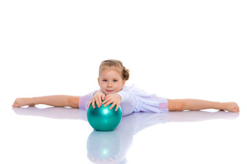 little girl is engaged in fitness with a ball.