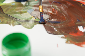 Obraz premium Green can with paint and mixing colors on paper.
