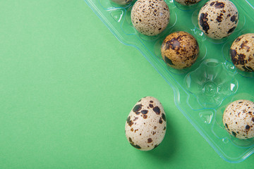 Beautiful spotted fresh quail eggs on a green paper background