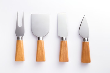 Cheese cutter set with wooden handles. Group of cheese knives on a wooden background. Top view