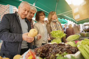 Senior people at the farmer's fresh market buying fruits and vegetables