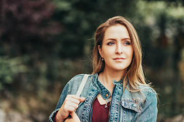 Outdoor portrait of young woman wearing denim jacket