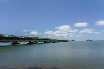Fototapeta na wymiar Tinsulanonda bridge with smooth cloud and sea in broad daylight