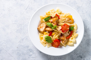 Pasta with chicken and vegetables top view on stone table. 