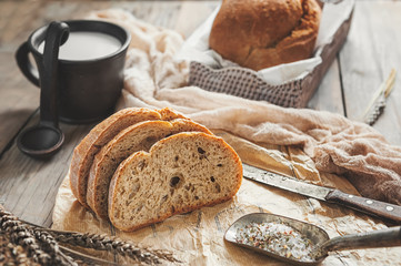 Naklejka premium A beautiful loaf of sourdough bread from white wheat on a plate on a linen edge. Homemade pastries.