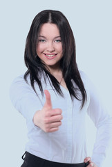 Successful business woman posing against gray background.