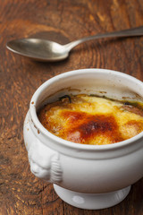 Französische Zwiebelsuppe mit Käse auf Holz