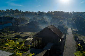 morning on countryside, village in haze, Bali roof,