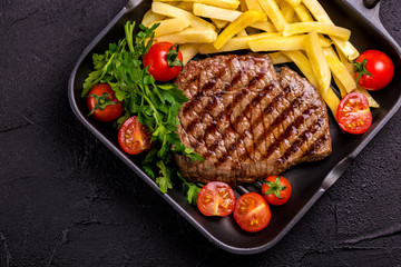 Grilled beef steak with tomatoes, french fries. Barbecue, bbq meat